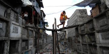  Filipino children walk between the tombs of the Navotas municipal cemetery, north of Manila, where they live. 